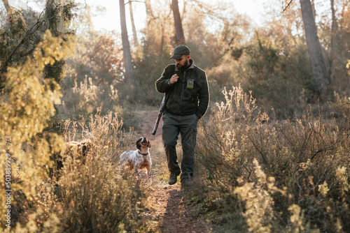 Man hunting with dog in autumn woods photo