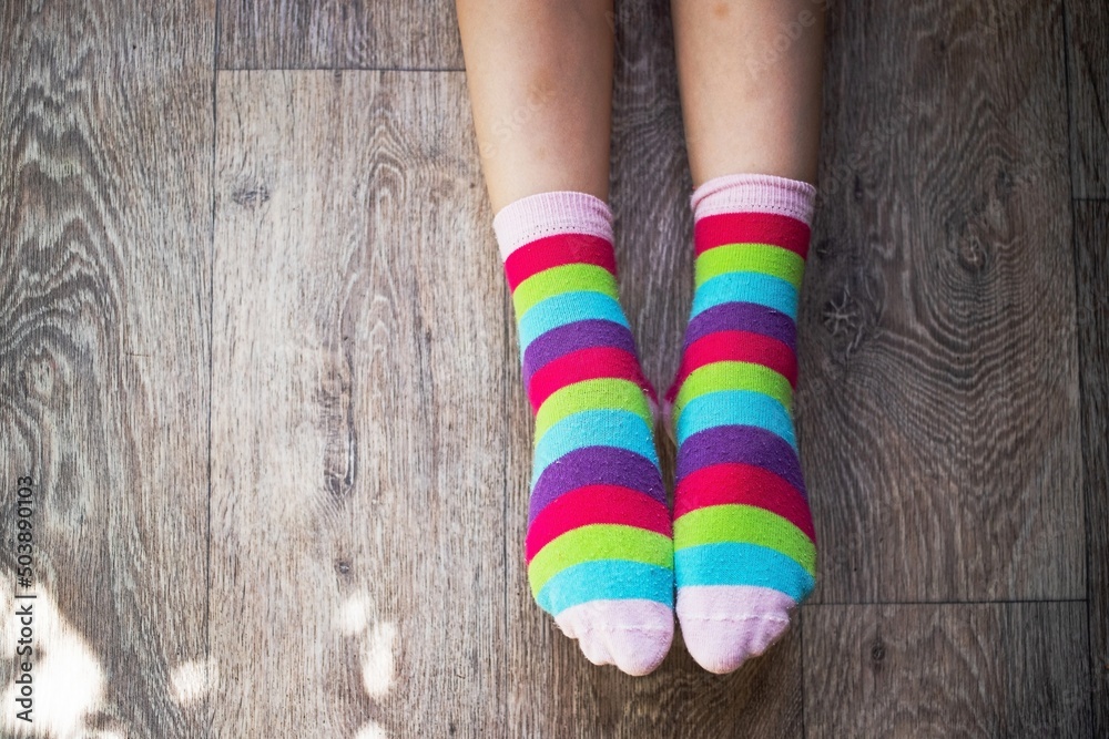 girl child shows two socks with rainbow colors put on her feet as a symbol or concept of lgbt community or protest girl child shows two socks with rainbow colors put on her feet as a symbol or concept of lgbt community or protest