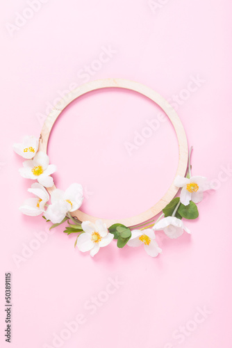Summer or spring composition on a pink background. Wooden frame with anemone flowers with copy space. Summer, spring floral concept