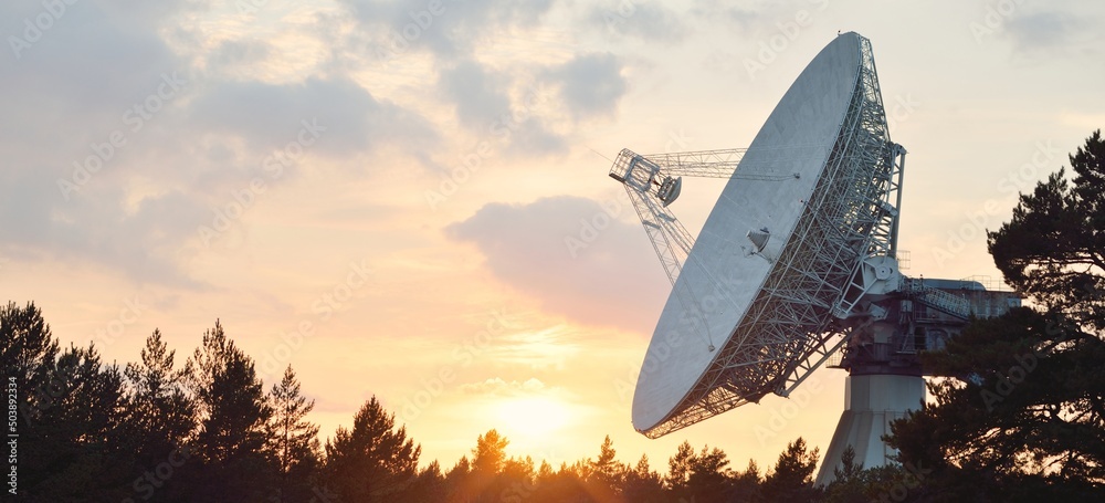Large radio telescope. Dramatic sunset sky, glowing clouds. Nature, weather, science, equipment, technology, international security, communications, remote places - obrazy, fototapety, plakaty 