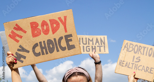 Protesters holding signs My Body My Choice, Abortion Is Healthcare, Human right. People with placards supporting abortion rights at protest rally demonstration. photo