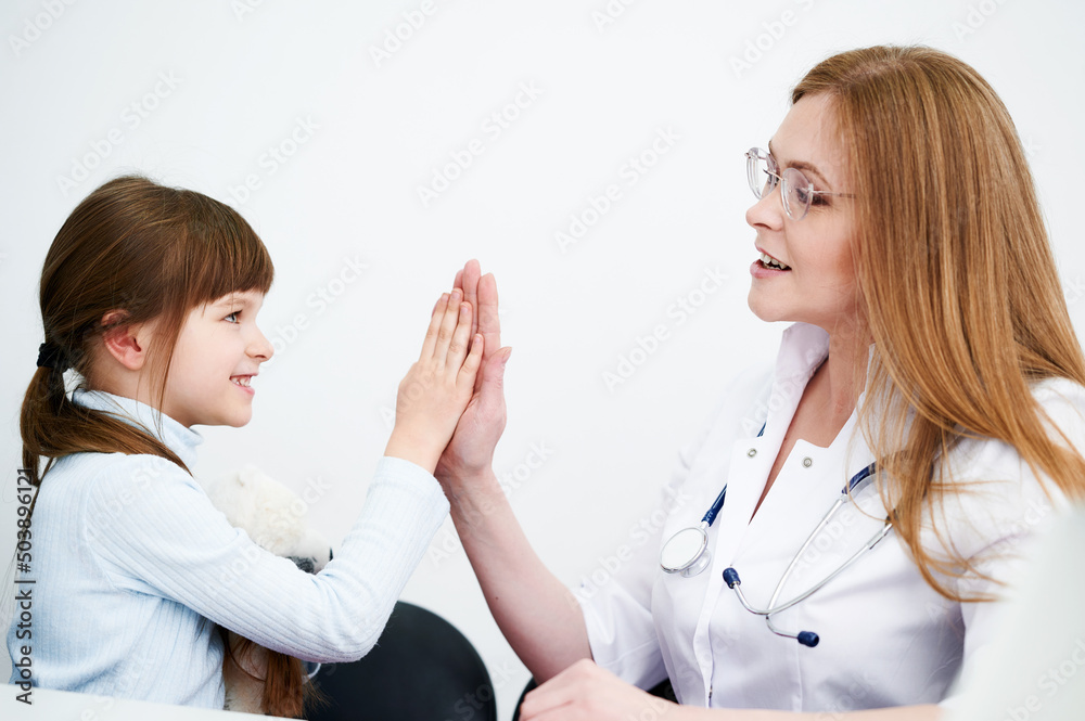 Creative professional female pediatric giving her little patient a high five Creative professional female pediatric giving her little patient a high five