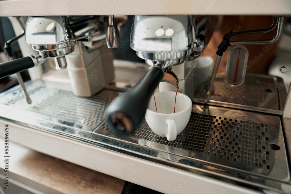 Close up of delicious fresh espresso pouring into white cup from coffee machine Close up of delicious fresh espresso pouring into white cup from coffee machine
