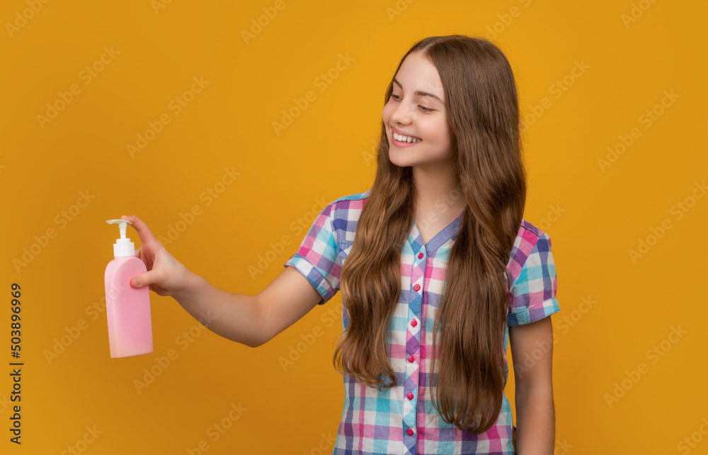 smiling kid with liquid soap bottle on yellow background smiling kid with liquid soap bottle on yellow background
