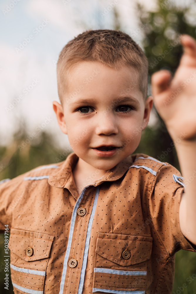 A little boy stands in nature and smiling A little boy stands in nature and smiling