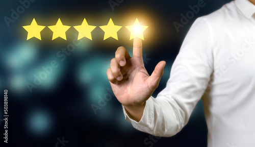Hand of businessman touching five star symbol to increase rating of company concept.