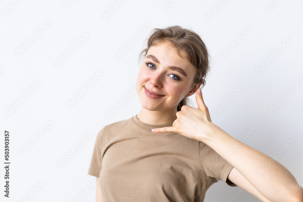 beautiful young woman shows gesture call me back on white background beautiful young woman shows gesture call me back on white background