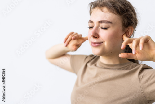 Portrait of angry stressed out young woman plugging ears with fingers and closing eyes tight, irritated with loud annoying noise, having headache or migraine. Negative human emotions