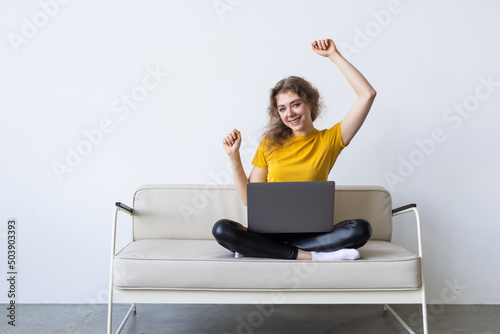 Young woman with credit card and laptop sitting on sofa at home © F8  \ Suport Ukraine