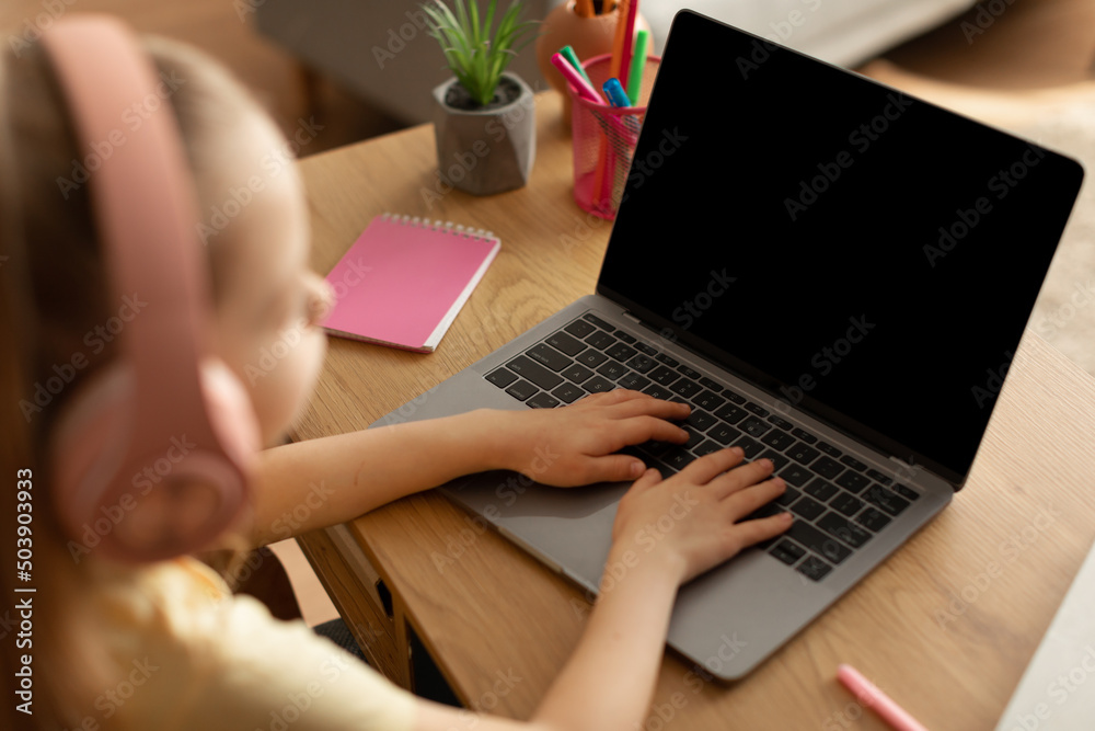 Little Girl Using Laptop Computer With Blank Screen Learning Indoors Little Girl Using Laptop Computer With Blank Screen Learning Indoors