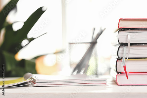 A stack of textbooks on the windowsill and writing stationary