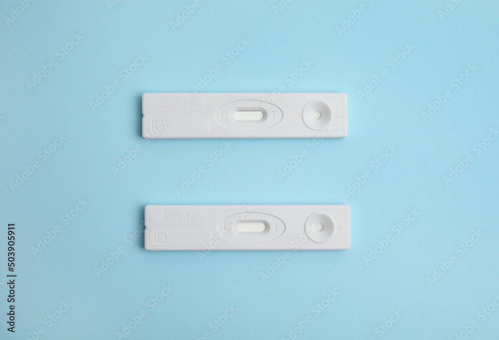 Two disposable express tests for hepatitis on light blue background, flat lay Two disposable express tests for hepatitis on light blue background, flat lay