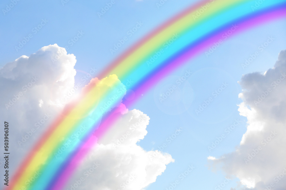 Beautiful view of bright rainbow in blue sky on sunny day