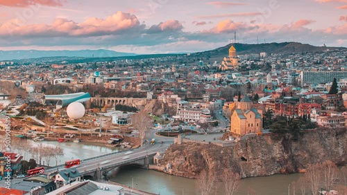 Tbilisi, Georgia. day to night time lapse timelapse. Top View Of Famous Landmarks In spring sunset Evening dusk night. Georgian Capital Skyline Cityscape. Justice House, Bridge Of Peace, Concert Hall photo