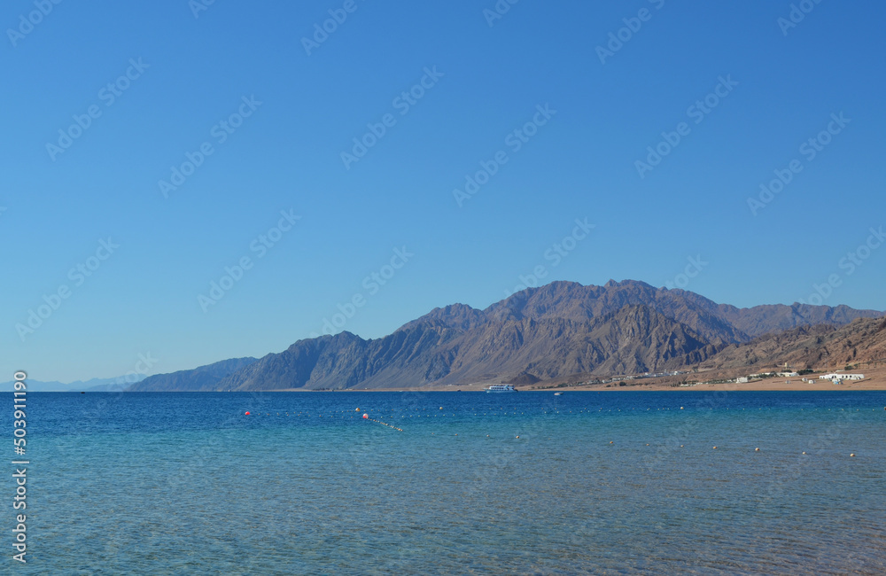 The view of Dahab lagoon in the background of distant mountains. The Sinai peninsula, Egypt.