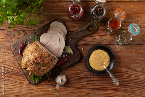 Crispy, cooked ham. Served with spices on a wooden board.