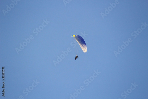 Parachutist on a blue sky background.