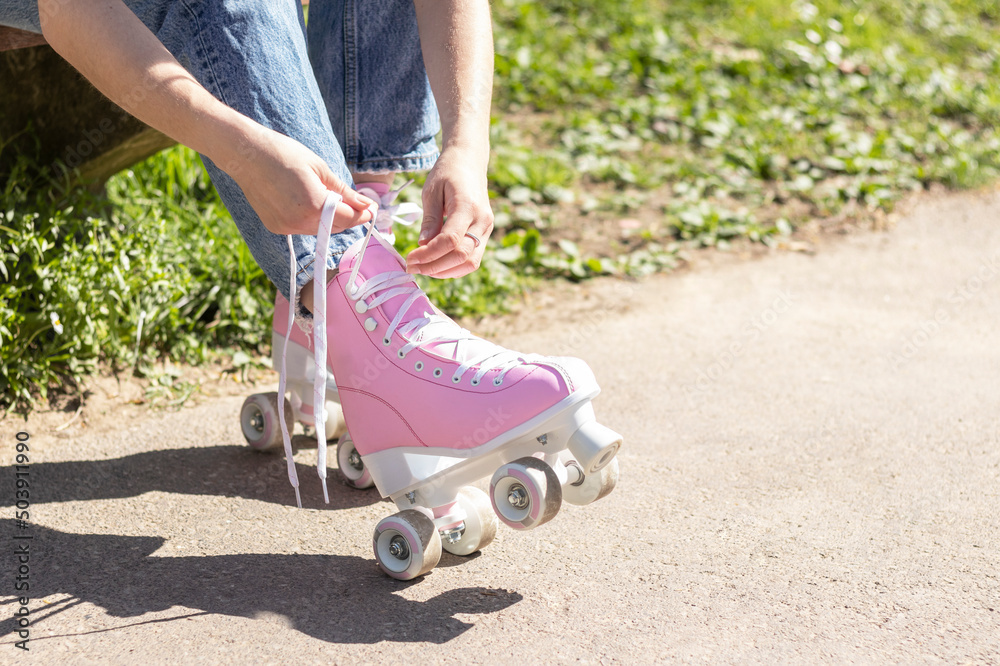 Obraz premium legs of a woman tying pink roller skates