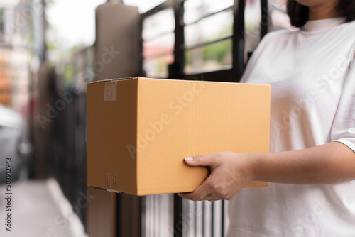 Wallpaper Mural Postal service sending paper cardboard box to customer in front of a house outdoor. Shipping service arrival and send to customer address. Torontodigital.ca