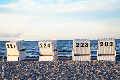 Foto Four beach chairs on the sandy beach at the baltic sea.