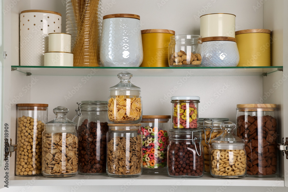 Glass containers with different breakfast cereals and other products on shelves Glass containers with different breakfast cereals and other products on shelves