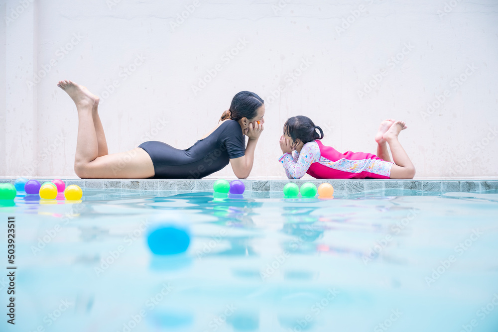 Mother baby girl enjoying a day at the pool, summer vacation concept.