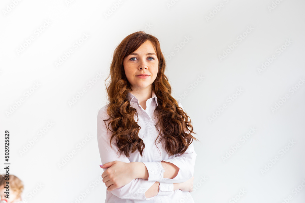 Young caucasian woman in casual clothes. The smile of a beautiful woman. Long curly red hair