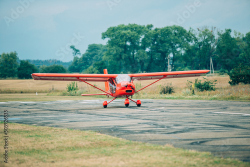 Red plane on the runway. Single turboprop aircraft parked on runway in sunny day. Travel sport concept. Ready for fly. small red propeller plane. 