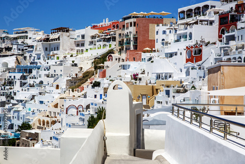 Traditional greek white houses on Santorini coast near the Aegean Sea. Village on the cliff under blue sky.