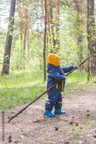Toddler boy walks in the forest
