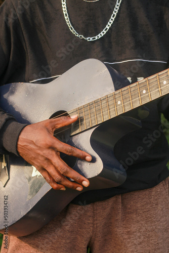 Midsection of man holding acoustic guitar
