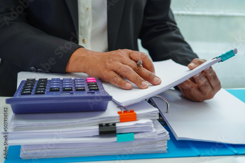 Businessman working and prepare paperwork report data to analysis information in file binder at office.