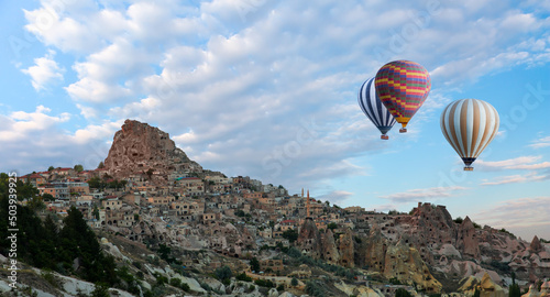 Hot air balloon flying over spectacular Cappadocia, Uchisar castle in the background - Goreme, Turkey