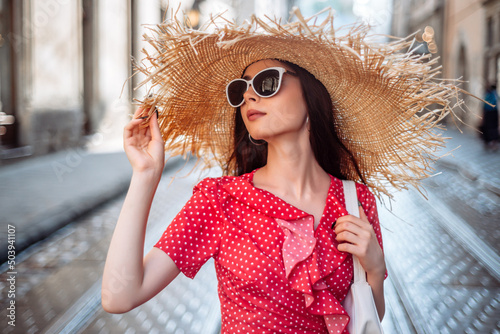 Summer girl with straw hat and sunglasses in red polka dot dress