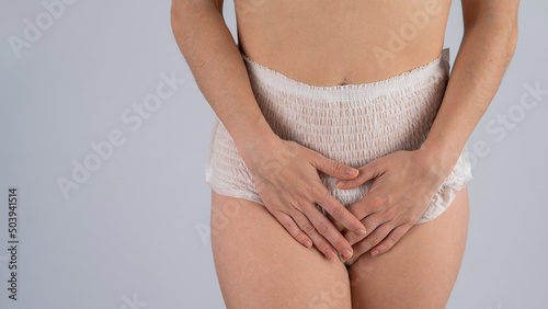 Photography A woman in adult diapers holds her hands on her stomach