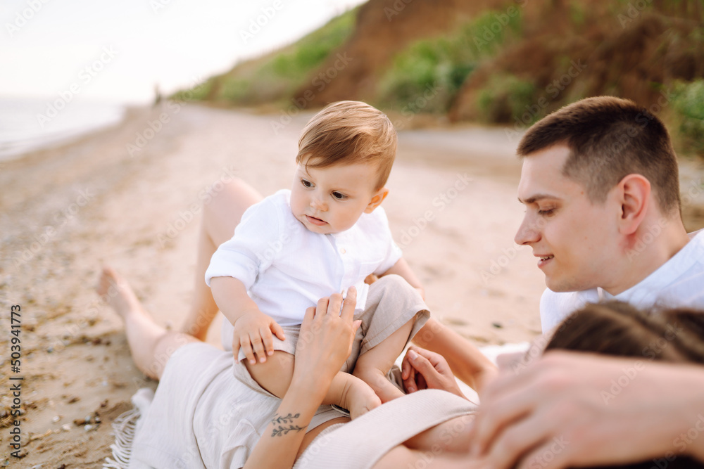Father, mother and child resting on the beach. Young family are having fun on summer vacation. Travel, nature, active lifestyle, resort concept. Father, mother and child resting on the beach. Young family are having fun on summer vacation. Travel, nature, active lifestyle, resort concept.