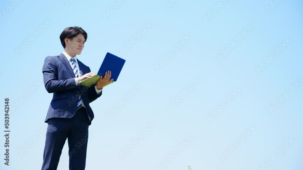 ノートパソコンを操作する若いビジネスマン　ビジネスイメージ