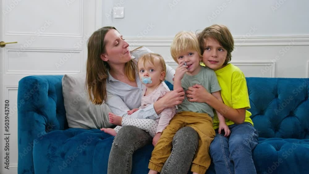 Family time - mother with children sit hugging on a coach Family time - mother with children sit hugging on a coach