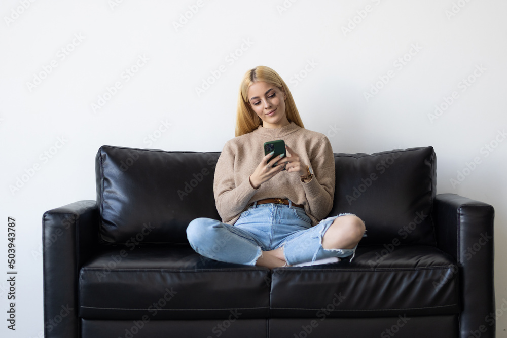Smiling young lady chatting in social networks, watching funny videos, using mobile applications at home. Smiling young lady chatting in social networks, watching funny videos, using mobile applications at home.
