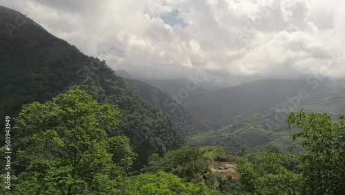 Side truck move. Aerial view on green mountains with fast moving clouds