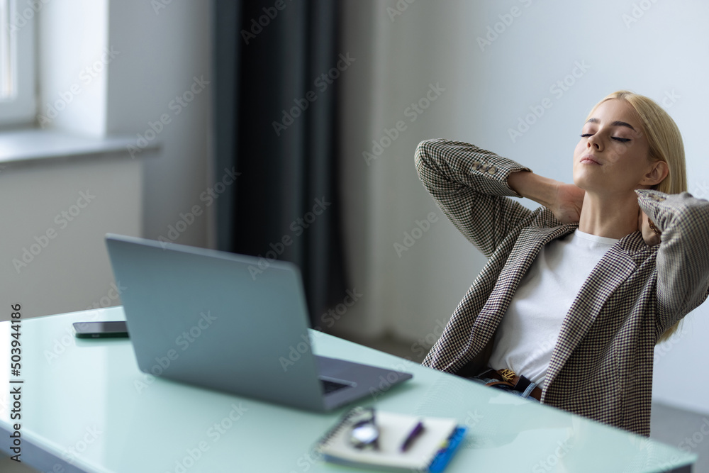 Beautiful stressed young woman office worker sitting at desk holding head because of pain in office Beautiful stressed young woman office worker sitting at desk holding head because of pain in office