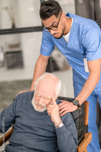 Healthcare worker consoling a despondent aged man