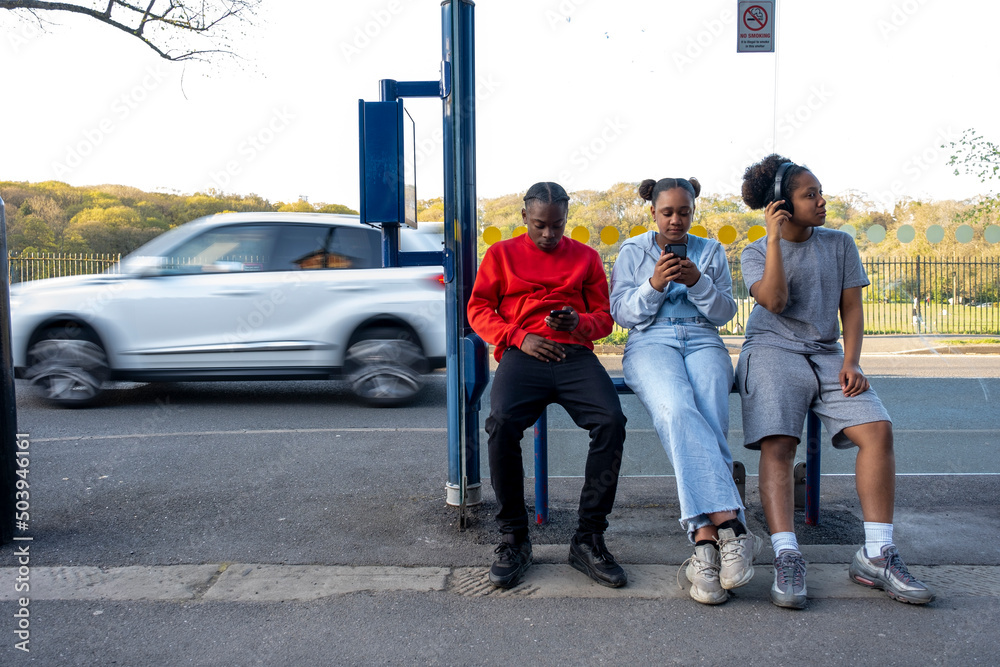 Friends sitting at bus stop Friends sitting at bus stop