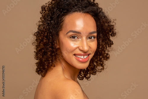 Studio portrait of smiling woman with curly hair