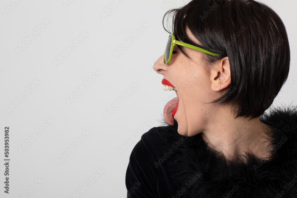 Woman sticks out her tongue on white background