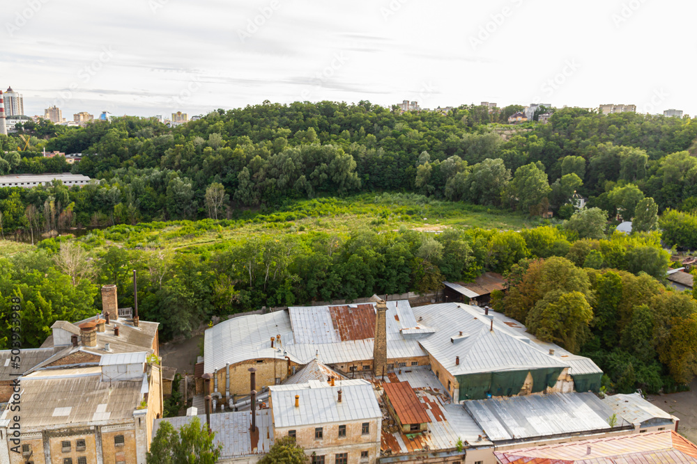 Fototapeta premium Kyiv, Ukraine – July 08, 2017: A beautiful panorama of Podil area. Aerial view on residential and industrial areas. A lot of buildings of different architectural style. Historical area, Dnipro river.