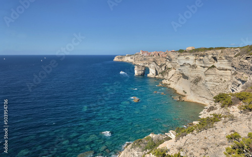 Bonifacio coastline with limestone cliff overlooking the sea on clear blue sky