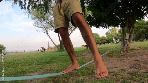 Close up of Professional male acrobat balancing on slack line at Vicente Lopez Park,Buenos Aires Argentina. photo