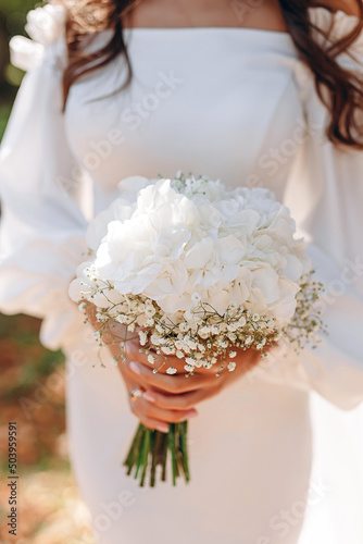 beautiful white wedding bouquet in the hands of the bride. flowers gypsophila and peonies