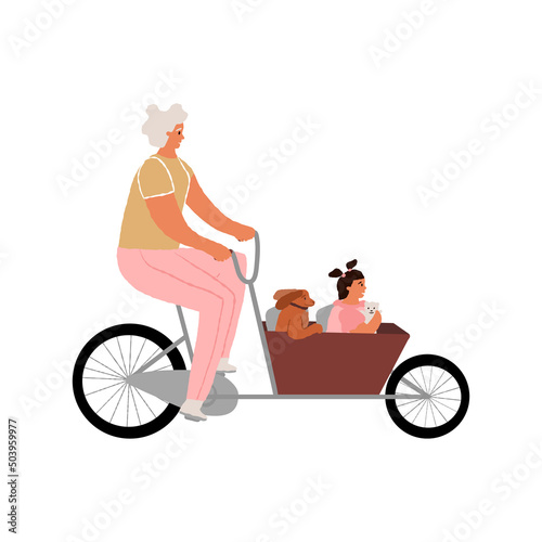 Elderly Woman, grandmother riding a cargo cycle, bakfiets with her granddaughter and dog. Family outdoor active pastime.